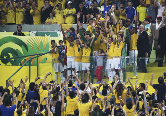 Los jugadores de la seleccin brasilea celebran el ttulo tras la final de la Copa Confederaciones; abajo, los jugadores de la seleccin espaola, al trmino del partido.