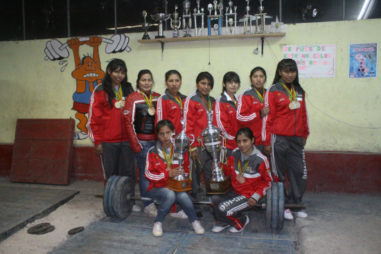 La seleccin de halterofilia (arriba) posa con su trofeo. Abajo, las chicas de softbol en el torneo de Tarija.