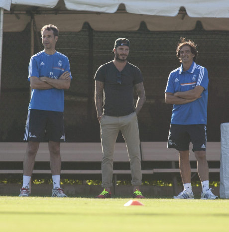 El ex futbolista David Beckham (c) observa el entrenamiento del Real.