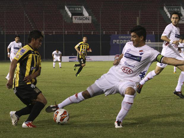 El atigrado Nelvin Solz (i) pierde el baln ante la marca de un jugador paraguayo, en el choque entre The Strongest y Nacional anoche, en Asuncin.