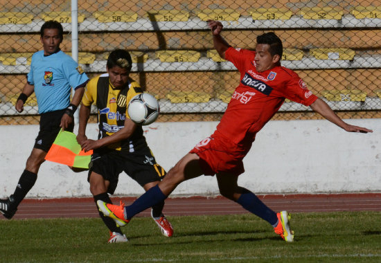 El lateral izquierdo Enrique Flores intenta evitar el remate de su rival de The Strongest; abajo, los jugadores estudiantiles se retiran de la cancha entristecidos por la derrota.