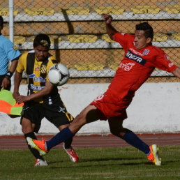 El lateral izquierdo Enrique Flores intenta evitar el remate de su rival de The Strongest; abajo, los jugadores estudiantiles se retiran de la cancha entristecidos por la derrota.