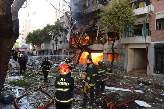 EXPLOSIN. Bomberos en las afueras del edificio, en Rosario, sofocan el fuego.