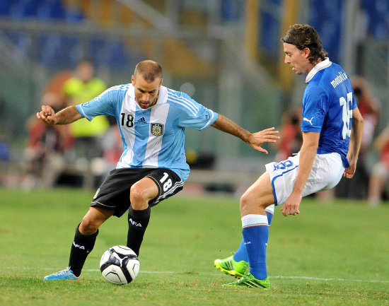 Rodrigo Palacio (i) intenta evadir a su rival italiano.