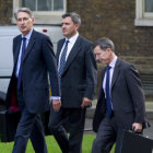 CONFLICTO. El ministro britnico de Defensa, Philip Hammond (izq), y un par de sus consejeros llegan a Downing Street para evaluar la crisis.