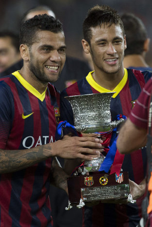 Los jugadores brasileos del Barcelona Dani Alves (i) y Neymar, con el trofeo de la Supercopa de Espaa.