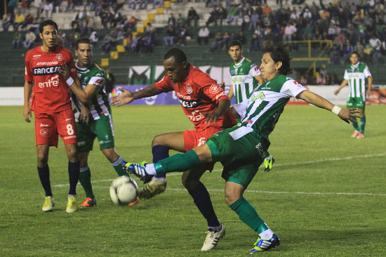 El delantero de Universitario, Gustavo PInedo, disputa el balon con el lateral de Oriente, Marvin Bejarano, durante el partido de anoche.