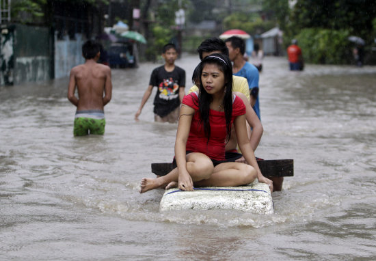 AFECTADOS. Habitantes de la provincia de Cantn se desplazan por una calle inundada.