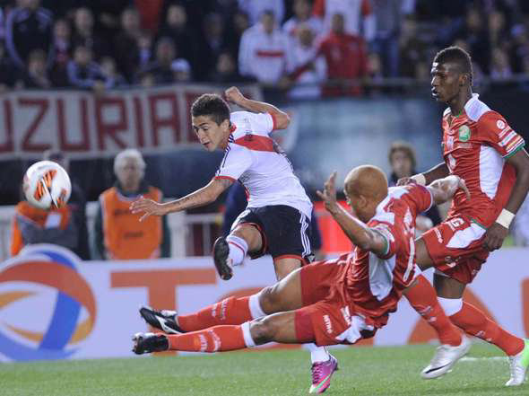 El jugador de River Plate, Manuel Lanzini, dispara un baln ante la marca de un jugador ecuatoriano de Liga de Loja.