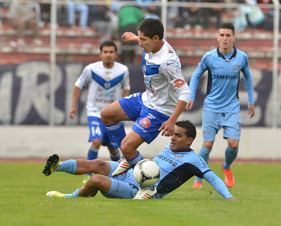 El uruguayo William Ferreira, de Bolvar, se barre al piso en procura de robarle el baln a un jugador rival.