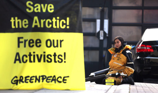 PROTESTA. Un activista de Greenpeace permanece encadenado a un surtidor de gasolina para demandar la liberacin de sus colegas.