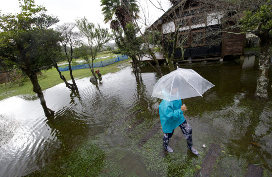 TORMENTA. Una mujer camina en medio de la inundacin en su finca, tras el paso del tifn Wipha en Japn.