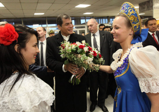 VISITA. Rafael Correa recibe un ramillete de flores de una joven a su llegada a Mosc.