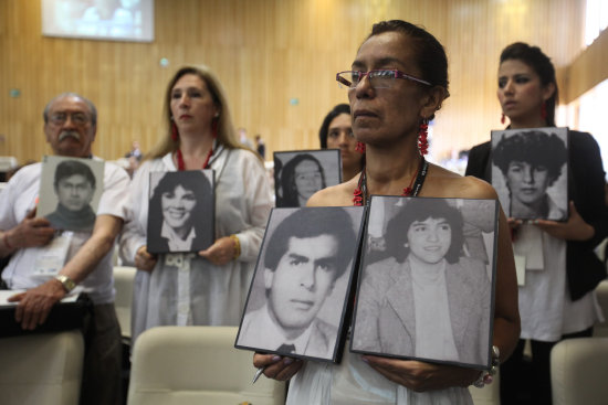 RECLAMO. Familiares de las vctimas sostienen fotografas durante la audiencia de ayer.