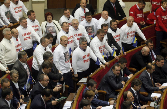 PROTESTAS. Diputados de oposicin con camisetas con la ex primer ministra Yulia Timoshenko reaccionan durante una sesin parlamentaria.