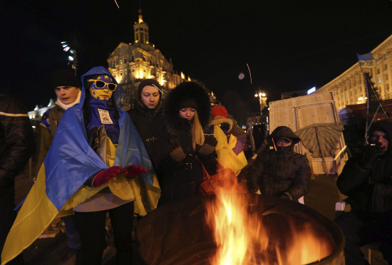 DESAFO. Manifestantes se agrupan en torno a un fuego durante una manifestacin en Kiev.