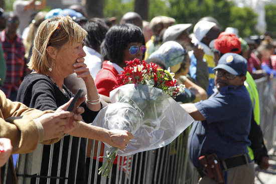 TRISTEZA. Sudafricanos lloran la muerte de su ex presidente Nelson Mandela.