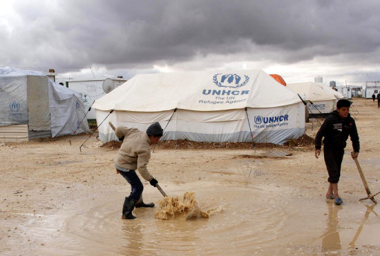 INCLEMENCIA. Unos nios intentan drenar una parte del campo de refugiados de Zatari en Mafraq en medio de una ola de fro.