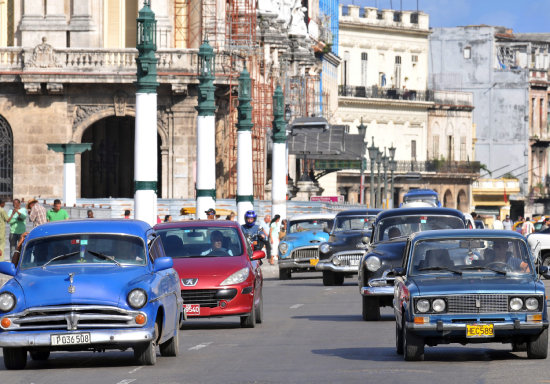 RENOVACIN. Varios autos circulan por una calle de La Habana. El parque automotor cubano sufrir una transformacin.