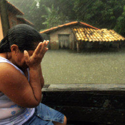 DESASTRE. Una mujer llora de impotencia frente a su casa inundada mientras la lluvia no deja de caer.