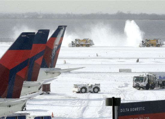 TEMPORA. Mquinas quitanieves trabajan en una de las pistas del aeropuerto JFK de Nueva York, Estados Unidos.