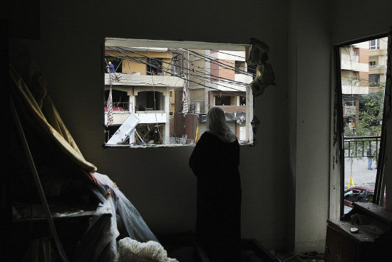 DESTROZO. Una mujer inspecciona su casa, tras un reciente atentado en Beirut.