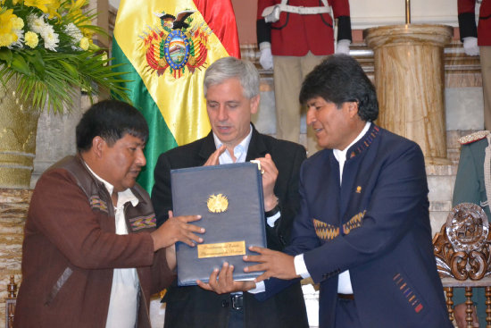 ACTO. El presidente Evo Morales entrega la norma al presidente de la FAM, Juan Carlos Len.