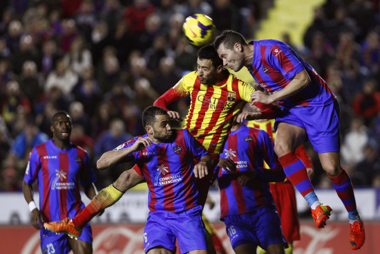 El volante del Barcelona Sergio Busquets (c) lucha un baln ante la marca de los defensores rivales.