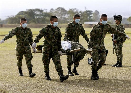 GUERRA. Miembros del Ejrcito de Colombia trasladan los cuerpos de miembros de las FARC.