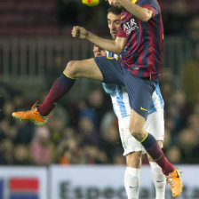 El volante del Barcelona Sergio Busquets (d) salta por el baln ante la presin de un jugador rival.