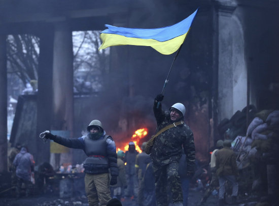 PROTESTAS. Desafiando la nieve y el fro, manifestantes lanzan consignas contra el gobierno ucraniano durante una jornada de violencia en Kiev.