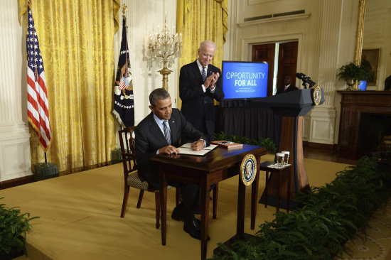 MIGRACIN. Barack Obama firma documentos en su despacho de la Casa Blanca.