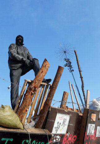 PROTESTAS. Un manifestante desafa a las fuerzas de seguridad desde una barricada.