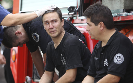 SINIESTRO. Bomberos argentinos lloran por la muerte de sus compaeros durante el incendio en el barrio de Barracas.