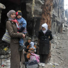 CONFLICTO. Varios residentes de Homs mientras esperan para ser evacuados de un campamento ante el recrudecimiento de la violencia.