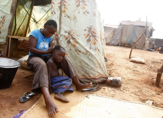 POBREZA. Imagen cotidiana de una mujer con su hijo en un campo de refugiados africano.