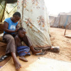 POBREZA. Imagen cotidiana de una mujer con su hijo en un campo de refugiados africano.