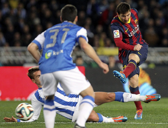 El argentino Leo Messi (d) golpea el baln ante los defensores de la Real Sociedad, durante el encuentro de ayer.