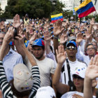 CONVOCATORIA. Un grupo de personas levanta sus manos en una avenida de Caracas.