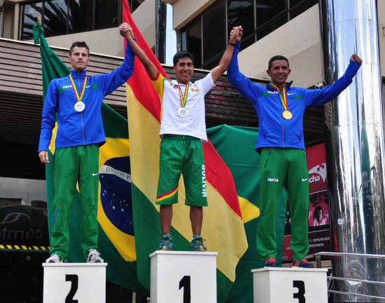 Quispe (c) celebra el triunfo en el podio.