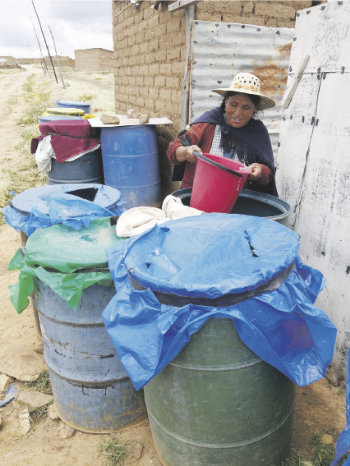 CARENCIA: La vecina de Villa San Manuel, Ana Mamani, recoge agua de uno de sus tres turriles que estn a unos 150 metros de su casa.