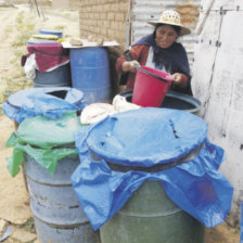 CARENCIA: La vecina de Villa San Manuel, Ana Mamani, recoge agua de uno de sus tres turriles que estn a unos 150 metros de su casa.