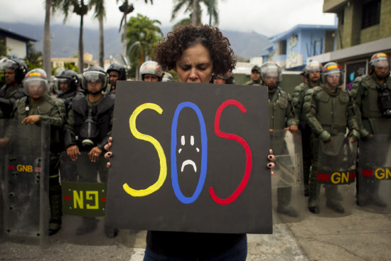 BARRICADAS. Militares intentan despejar una va bloqueada cerca de Caracas, en medio de una jornada de tensa calma.