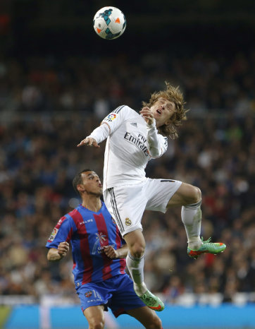 El volante croata del Real Madrid Luka Modric (d) remata de cabeza ante la marca de un jugador del Levante.