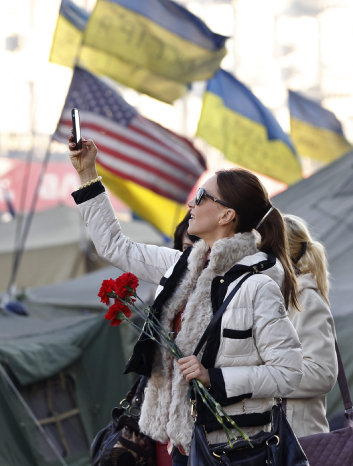 TENSIN. Una mujer ucraniana hace una fotografa en la plaza Independencia de Kiev.