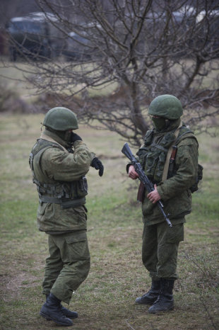 PREPARATIVOS. Dos hombres vestidos con uniformes militares patrullan una calle en Crimea.