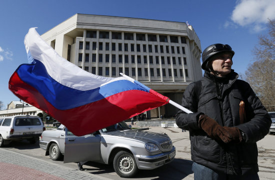 INDEPENDENCIA. Un crimeo ondea una bandera rusa cerca del Parlamento, tras el referndum en el que el los votantes apoyaron por mayora la anexin de su pas a Rusia.