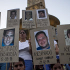 VCTIMAS. Manifestantes sostienen carteles con retratos de personas fallecidas.