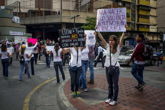 PROTESTAS. Un grupo de personas opositoras al Gobierno del presidente venezolano, Nicols Maduro, muestran unos carteles con mensajes de protesta en Caracas.