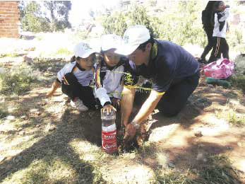 Campaa. La nia Milenka Serrudo plantando un rbol junto a su padre y una compaera.